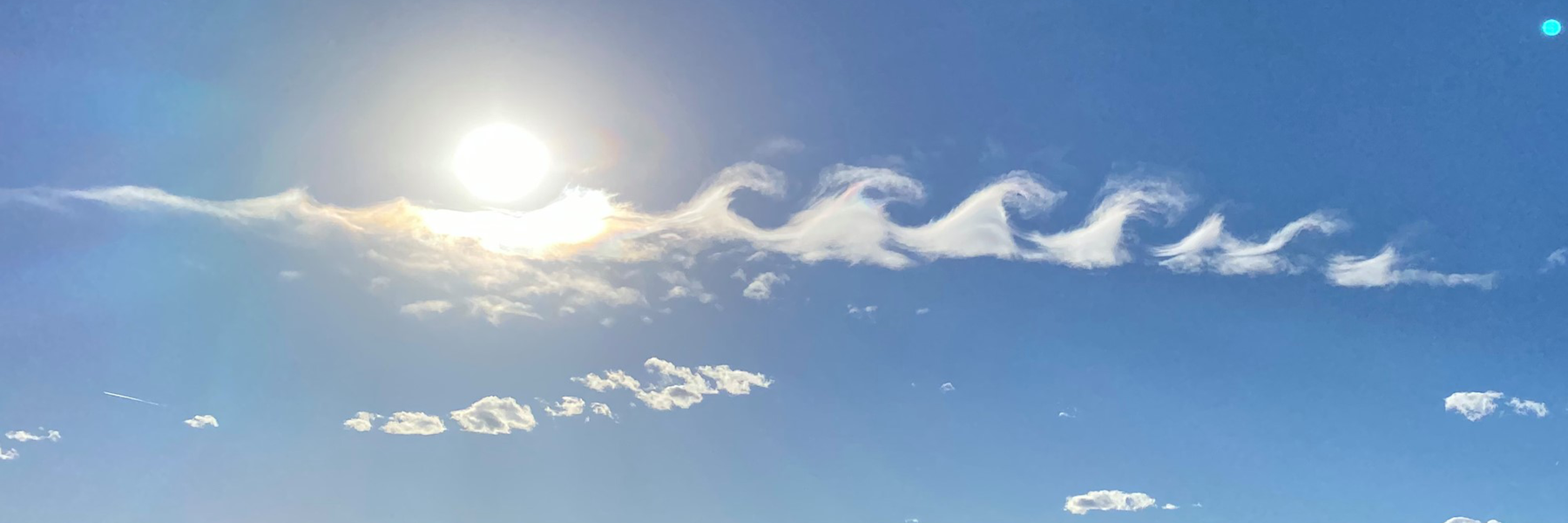Blue sky with sun and wave clouds, link to article